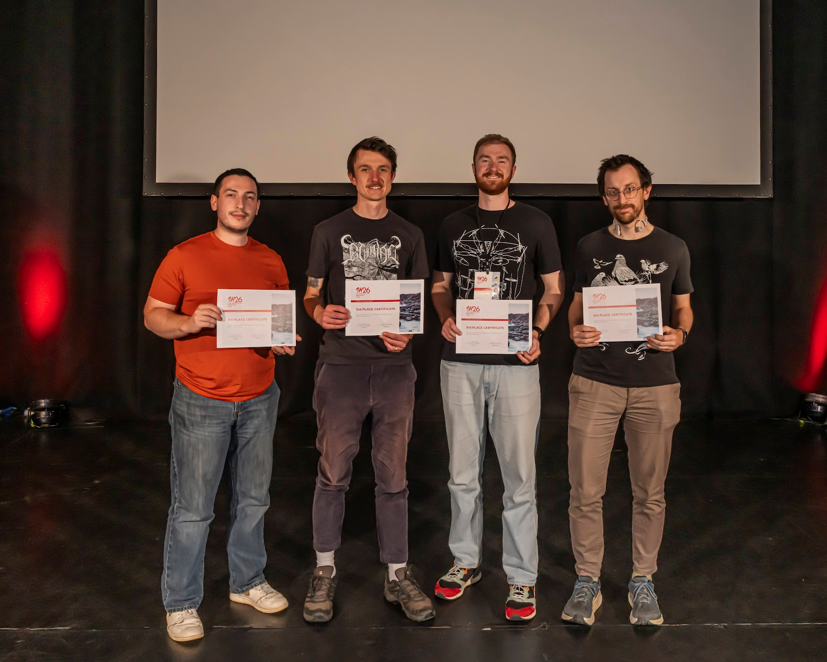 Four men (Dimitri, Joe, Connor, Alan) posing with third prize certificates.